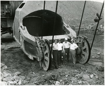 Frank Morovan and three others stand next to a Hanna Coal Co. giant shovel scoop.