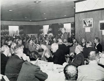 Visitors eat lunch at Hanna Coal Co. while one man stands and talks.