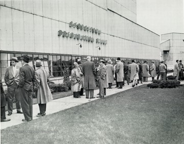 Men standing outside of the plant talking.