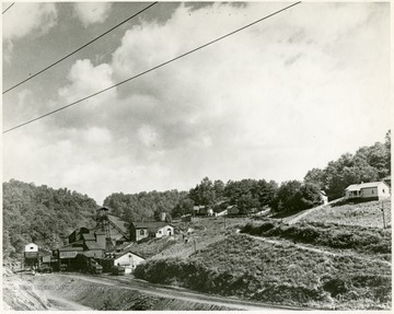 Tipple of a mine with houses for the miners located in the area behind the tipple.