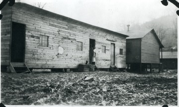 A man and woman are standing in doorway of barracks.