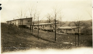 View of barracks through some trees.