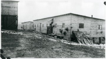 Barracks at Rivesville, W. Va. with baskets or washtubs hanging on outside. Also, coal storage on right.