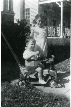 Helen Digit (standing) and John Digit III at 2 years old(sitting on a riding toy), Children of Luella Digit, Director of the Settlement House, 1936-1938.