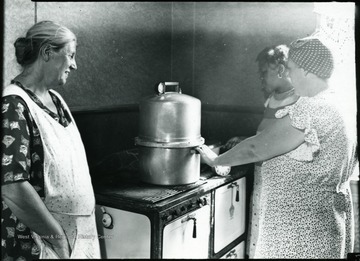 Women preparing food with a pressure canner.