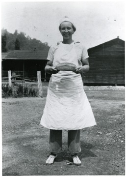 Woman holding loaf of bread.