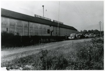 Men with cars outside of a National Youth Administration Building used as a salvage building.