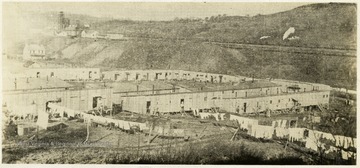 Several lines of laundry are hung around the wooden barracks which serve as homes for miners and their families. Published in "Bloodletting in Appalachia" by Howard B. Lee, p 152.