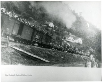 Train on the way to the front, passing through Ramage, Boone Co. Photo by Miss Sara Jane Pollock, Daughter of A.W. Pollock, gen. mgr. of Spruce R. Coal Co., whose house is the highest in this picture.