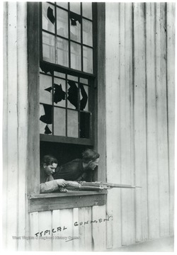 Two gunmen looking at a window with their guns.