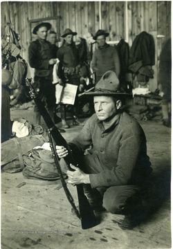 A Federal Trooper squats with his rifle.