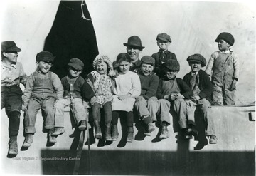 Children with man pose for picture outside a tent during the Ludlow Strike.