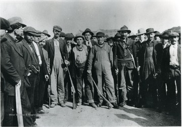 Group of armed men crowd together for a picture.