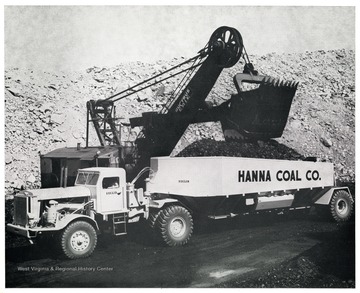 'Fifty-five ton tractor trailer units at Bradford No. 1 Mine near Cadiz, Ohio: Coal from the Bradford open-cut mine is loaded into 55-ton trator-trailer trucks to be transported to the Georgetown Preparation Plant where it is washed, dried and sized. Thes tractor-trailer trucks are powered by 400 H.P. Deisel V-12 engines. They have a rated capacity approximately equal to that of a railroad car (55-tons). The overall length of this unit is 55 feet. It is 12 feet in width and at its highest point, is 11 1/2 feet from the ground. The front tires on these units are 14:00 x 24. The rear tires on the tractor and the tires on the trailer are 18:00 x 25. These tractor-trailer units are lubricated while in operation by an electrically-times, automatically-controlled lubricating system, which lubricates each of the 63 bearings once each operating hour. Similar but slightly smaller capacity trucks are in use at the Georgetown No. 12 Mine. The coal is loaded, without being shot, by electric shovels having dippers of 9 cubic yards capacity.'