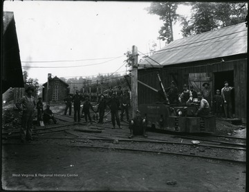 Miners sit and stand outside of the New River Coal Company Prudence No. 1 Mine located 4 miles from Thurmond, Fayette County, W. Va. '1906 or after.'