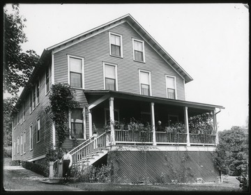 Woman standing on the front porch of a large house.  Man standing at the foot of the stairs.  W. R. Ballard and wife, superintendent for William McKell at Glen Jean.  House still standing in 2005.