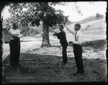 Three men holding guns.  Two are aiming at each other, one has the gun pointed to the sky.