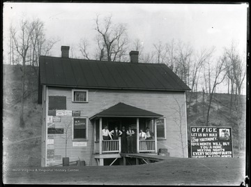 Five men and one woman stand on the porch of a real estate office in Glen Jean, W.Va.