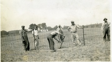 Men work on the fence at the Miner's Cemetery, Mt. Olive, Illinois.