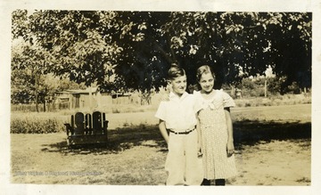 Boy and girl standing together.  Girl has her arm around the boy.  Photograph from Joe Ozanic scrapbook.