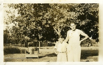 Joe Ozanic standing with arm around boy, tree in the background. Photograph from Joe Ozanic scrapbook.