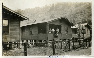 Four people, standing on a porch of a coal company house. Photograph from Joe Ozanic scrapbook.  