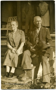 Couple is sitting on steps to house.