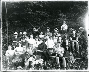 Group portrait of male and female students posed with different types of sports equipment.