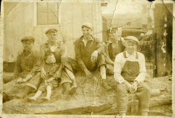 Five workers and little boy sitting together. 