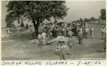 Young boy stands in front of groups of workers who helped with the Mother Jones Memorial.