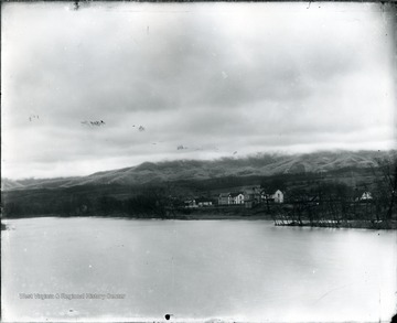 View of Keeney's Knob from a bridge at Alderson.  Houses by the shore.