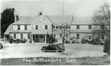 Front of the Arthurdale Inn with two cars parked outside.