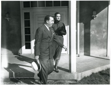 Doris Duke and Jennings Randolph walking off the porch. 