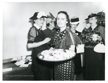 Lady holding a tray of finger foods at a reception in the Arthurdale Inn.