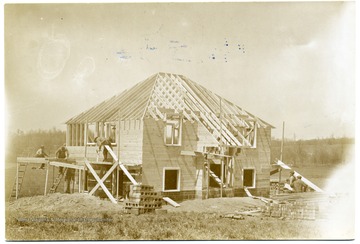 Men are placing siding on a house.