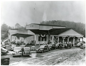 People parking their cars and gathering to go into the Silman Mnfg. Army-Navy awards.