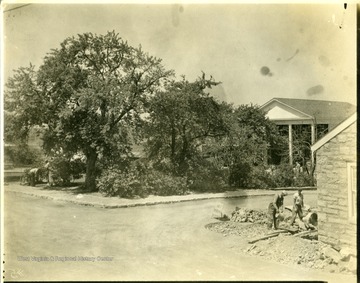 Men working on sidewalks and landscaping near the community center at Arthurdale.