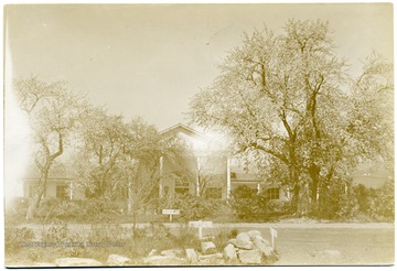 Community Center building with an entrance sign sits behind some trees.