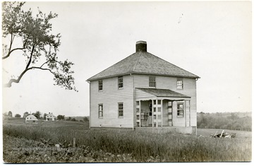 Two story house with two others in the distance.