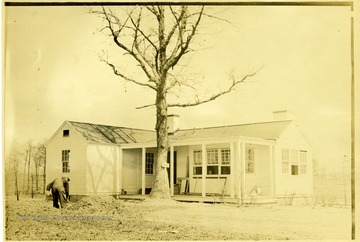 Man shoveling dirt outside house B-8.