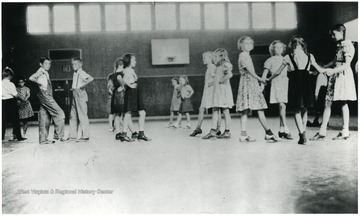 Girls and boys in formations with toes extended while learning to dance.