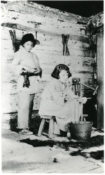 Boy standing, girl is dipping candles.