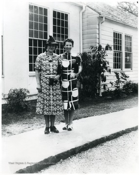 Elinor Morgenthau and a teacher pose together in front of Arthurdale School, Arthurdale, W. Va.