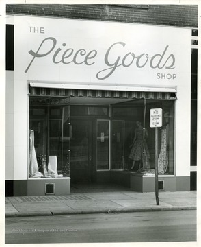 View of the store front of the Piece Goods Shop (1947-1952) in Beckley, West Virginia.  'Copyrighed 1955 All rights reserved by Harlow Warren 320 North Kanawha Street Beckley, W. Va.'