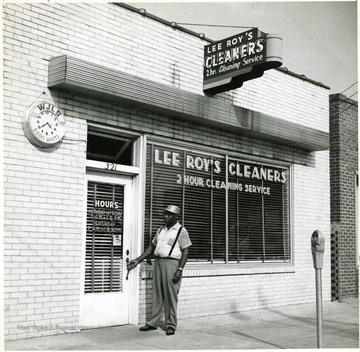An African-American man enters Lee Roy's Cleaners. 'Copyrighted 1955, All Rights Reserved By Harlow Warren, 320 North Kanawha St., Beckley, W. Va.'