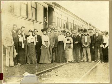 Townspeople are standing in front of a railroad car in Beckley, West Virginia. They include 1) unidentified musician; 2) unidentified captain; 3) Mrs. E.M. Payne, Sr. 4) Miss French?; 5) Mrs. Pearl (Sr.) Johnson; 6) S. Howe Johnson (Summerfield); 7) Miss Overton; 8) William Prince (on steps); 9) unidentified; 10) unidentified musician; 11) unidentified; 12) unidentified; 13) Gil Norton; 14-17) unidientified; 18-19 unidentified musicians; 20-22) unidentified; and 23) Daisy Rose Wailfong. 