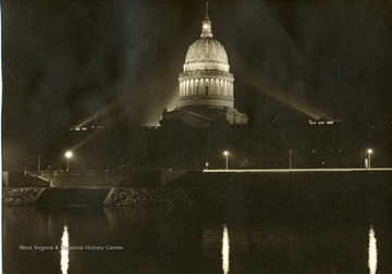 Lights illuminate the dome of the W. Va. State Capitol at night time.