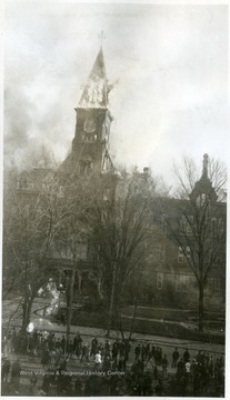 Crowd watches as flames erupt in the tower of the old capitol building.