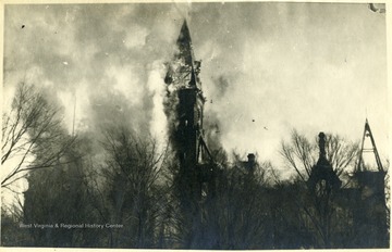 Flames and smoke surround the tower of the old Capitol building.