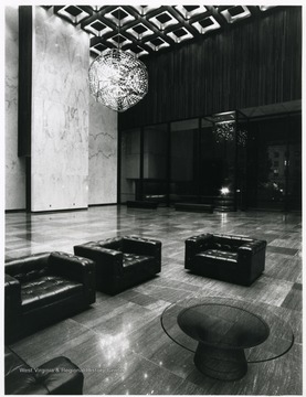 'The Great Hall greets guests to the new Science and Culture Center, its wood and marble expanse highlighted by a gold and wood coffered ceiling and two chandeliers.  Each chandelier weighs over 1000 pound and holds 92 lights.  The Hall may be used as a formal reception area, an expansion of lobby for the State Theater or a relaxing and mood-setting entrance to the Center itself.'